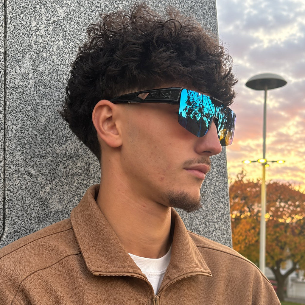Man wearing SUROIT blue mirror fit-over shield sunglasses at sunset